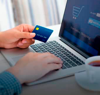 person using a credit card while typing on a laptop