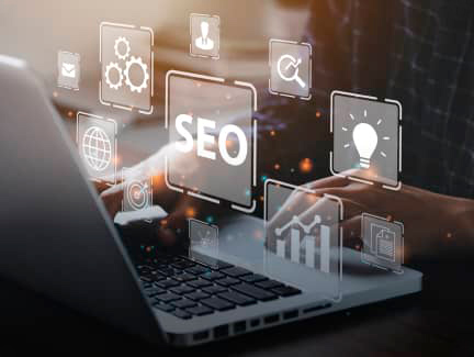 image showing a person typing in a laptop, the perspective is from behind the laptops, different icos are floating over the person typing